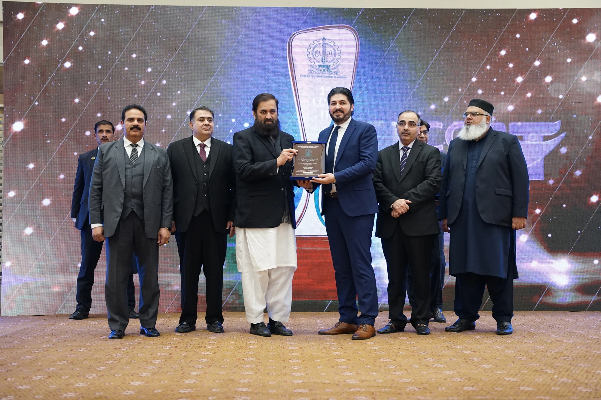 Shehryar T. Ali in a blue suit receiving a shield at the 2024 presentation by the Governor of Punjab.