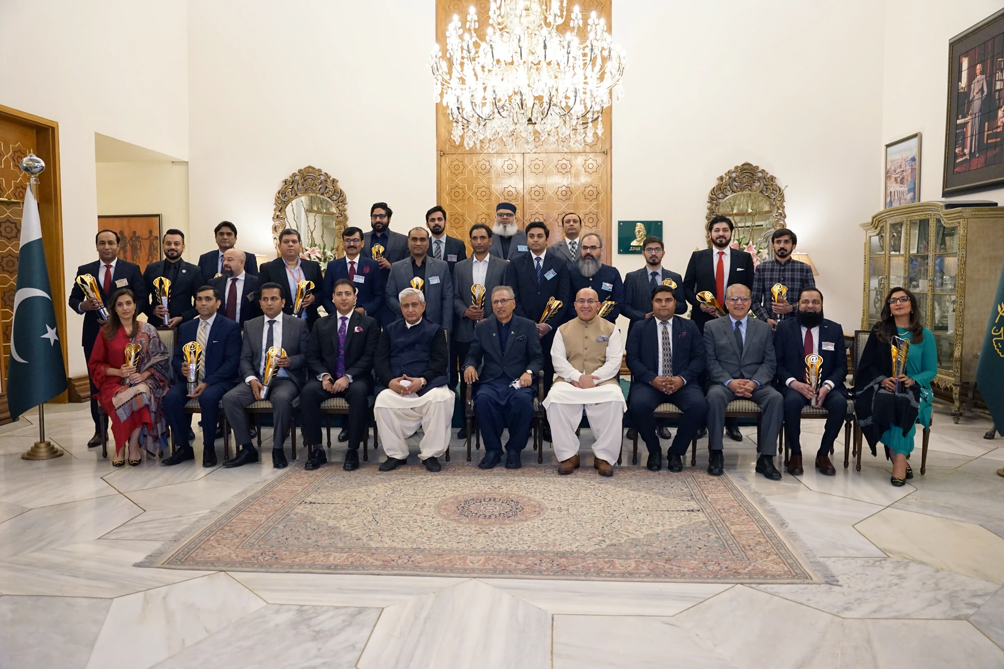 Shehryar T. Ali, wearing a red tie, with the award recipients and President of Pakistan at President House in March 2022.