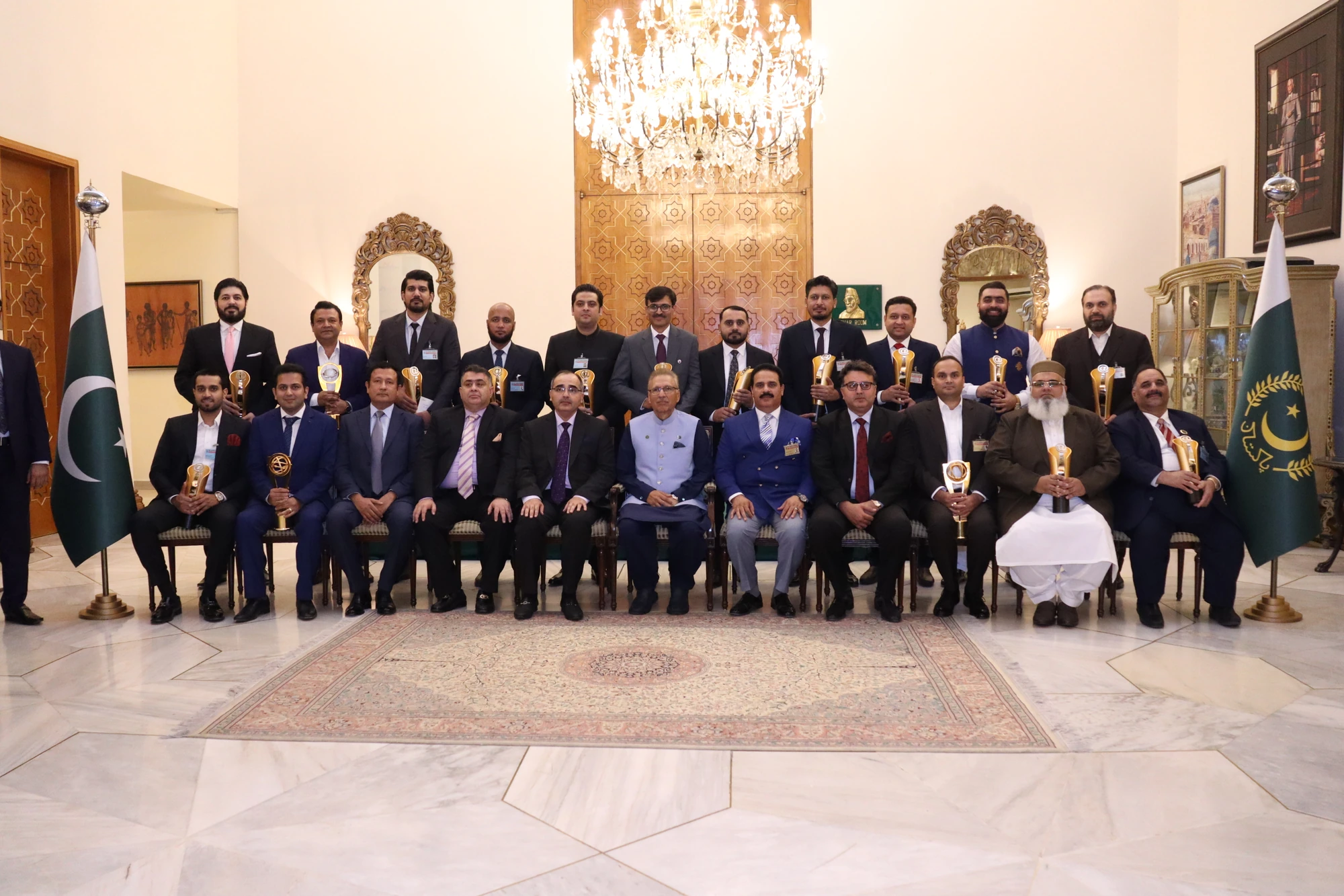 Shehryar T. Ali, wearing a pink tie, with the award recipients and President of Pakistan at President House in June 2023.